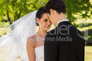 Romantic newlywed couple standing in park