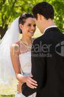 Romantic newlywed couple standing in park