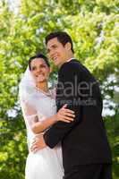 Romantic newlywed couple standing in park