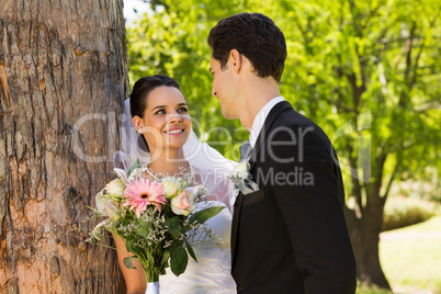 Romantic newlywed couple standing in park