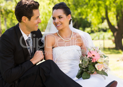 Smiling newlywed couple in park