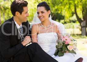 Smiling newlywed couple in park