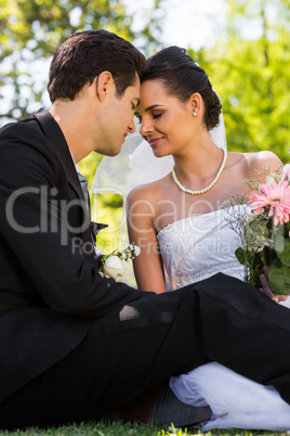 Romantic newlywed couple sitting in park