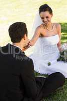 Groom kissing his beautiful bride's hand at park