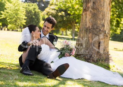 Happy newlywed couple relaxing in park