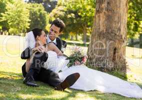 Happy newlywed couple relaxing in park