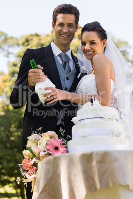 Happy newlywed with champagne bottle at park