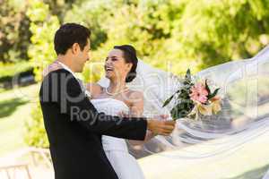 Cheerful newlywed couple dancing in park