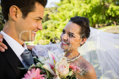 Romantic newlywed looking at each other in park