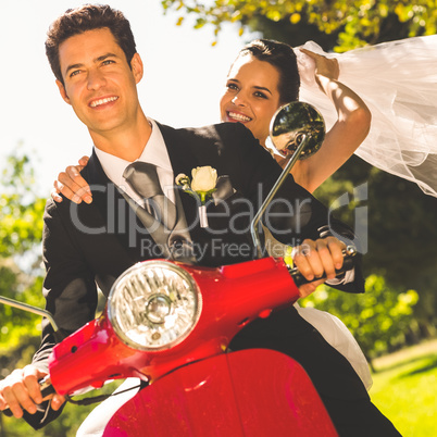 Newlywed couple enjoying scooter ride