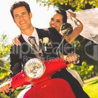 Newlywed couple enjoying scooter ride