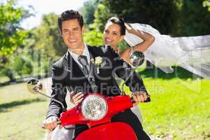 Newlywed couple enjoying scooter ride