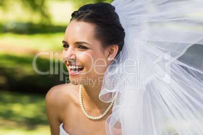 Cheerful young beautiful bride in park