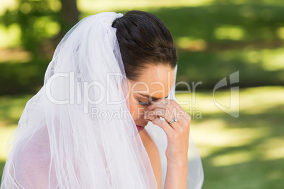 Close-up of beautiful worried bride at park