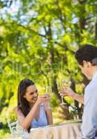 Couple toasting champagne flutes at an outdoor cafÃ©