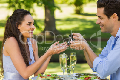 Man propose woman while they have romantic date at an outdoor ca