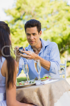 Man proposing a woman at an outdoor cafÃ©