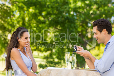 Man proposing woman at an outdoor cafÃ©