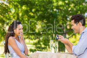 Man proposing woman at an outdoor cafÃ©