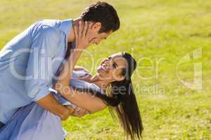 Loving and happy couple dancing in park