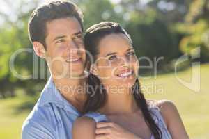 Loving and happy couple looking away at park