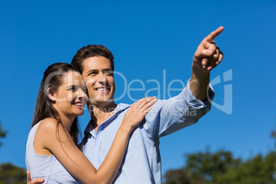 Couple looking away against clear blue sky