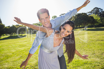 Happy couple with arms outstretched at park