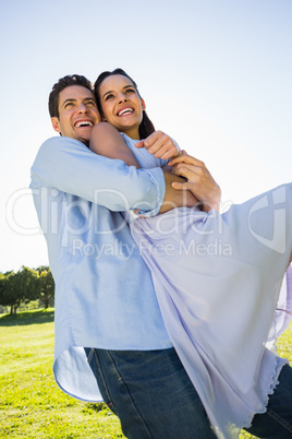 Happy man carrying woman at the park