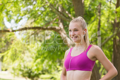 Healthy woman in sports bra jogging in park