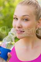 Close-up of a fit woman holding water bottle in park