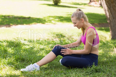 Healthy and beautiful woman in sportswear sitting in park