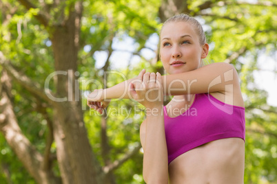 Healthy and beautiful woman stretching hand in park