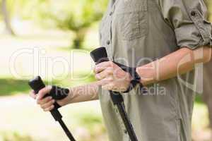 Mid section of a woman Nordic walking in park