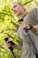 Beautiful young woman Nordic walking in park