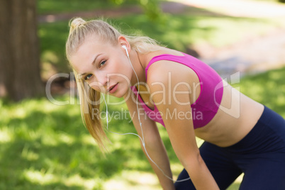 Tired beautiful woman in sports bra at park