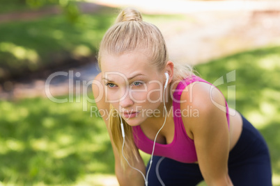 Tired beautiful woman in sports bra at park
