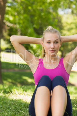 Healthy and beautiful woman doing stomach crunches in park