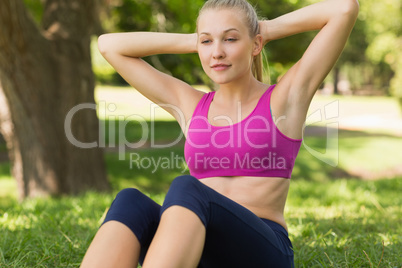 Healthy and beautiful woman doing stomach crunches in park