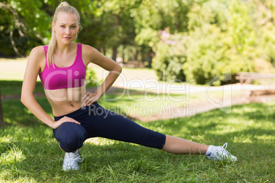 Healthy and beautiful woman stretching leg in park