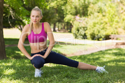 Healthy and beautiful woman stretching leg in park