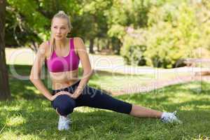Healthy and beautiful woman stretching leg in park