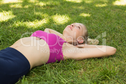 Relaxed beautiful woman lying on grass in park