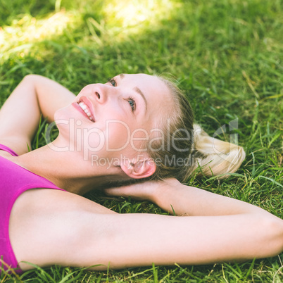 Relaxed beautiful woman lying on grass in park