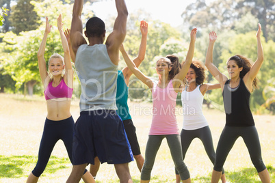 Group of fitness class exercising in park