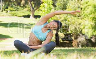 Healthy and beautiful woman doing stretching exercise in park