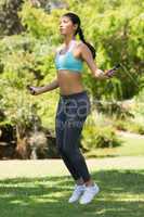 Healthy and beautiful woman skipping in park