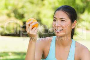 Close-up of woman holding orange in park