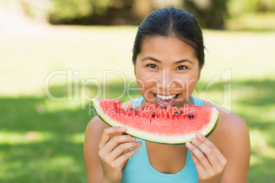 Portrait of a woman eating watermelon in park