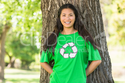 Smiling woman wearing green recycling t-shirt in park