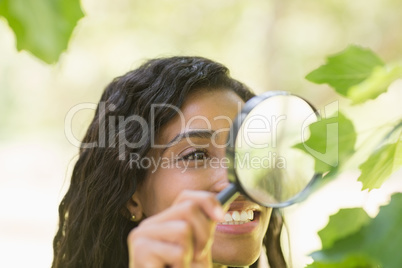 Woman examining leaves with magnifying glass